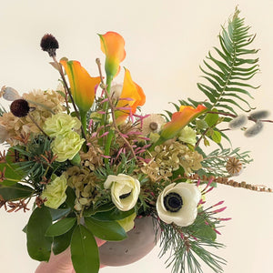 seasonal flowers and greenery in cement vase